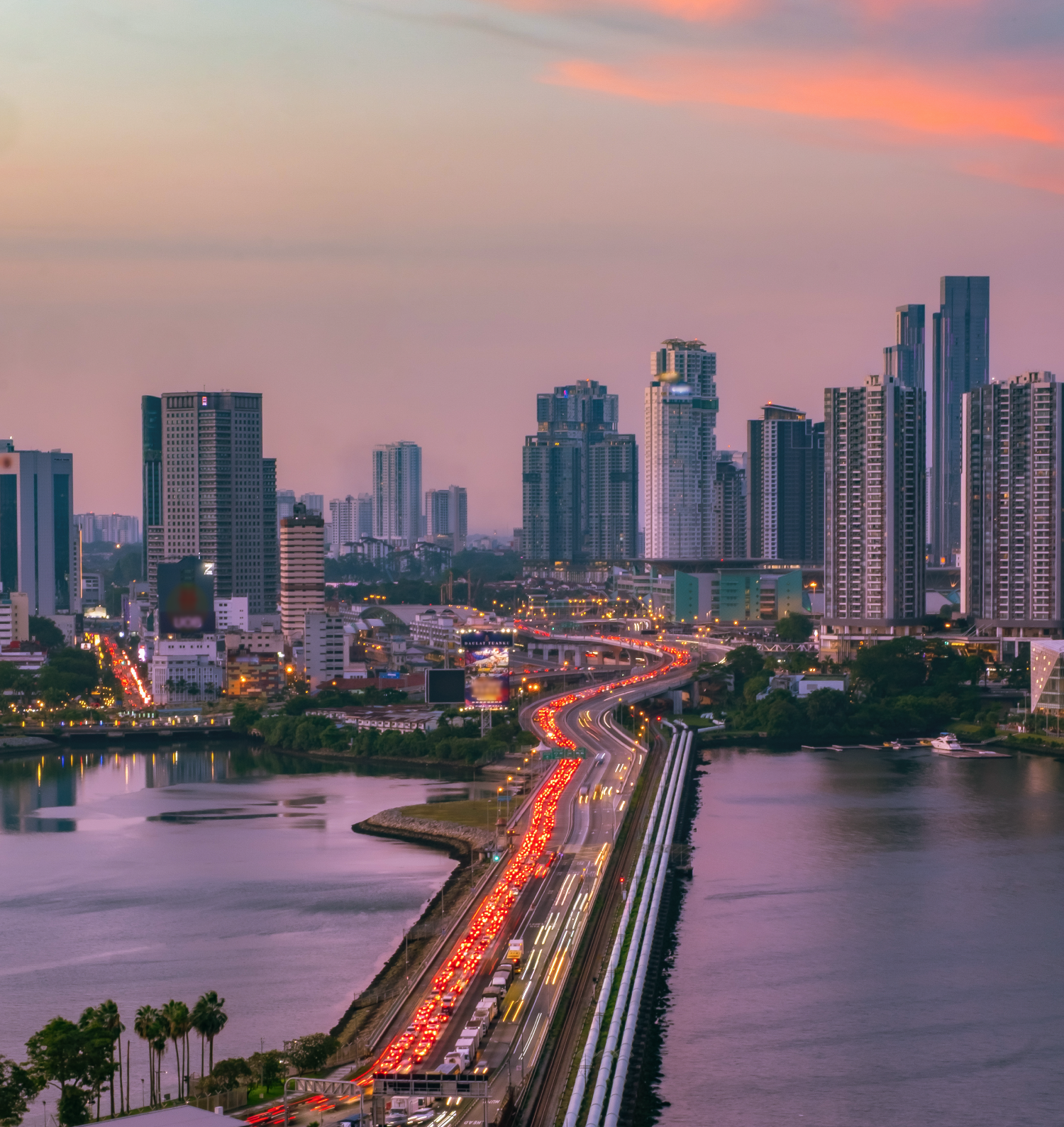 Evening view of the Johor–Singapore Causeway with heavy traffic leading into Johor Bahru’s skyline